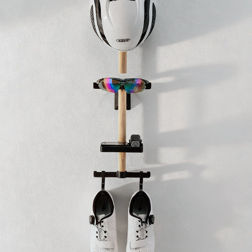 Wall rail holding a cycling helmet, sunglasses, a small tool and shoes