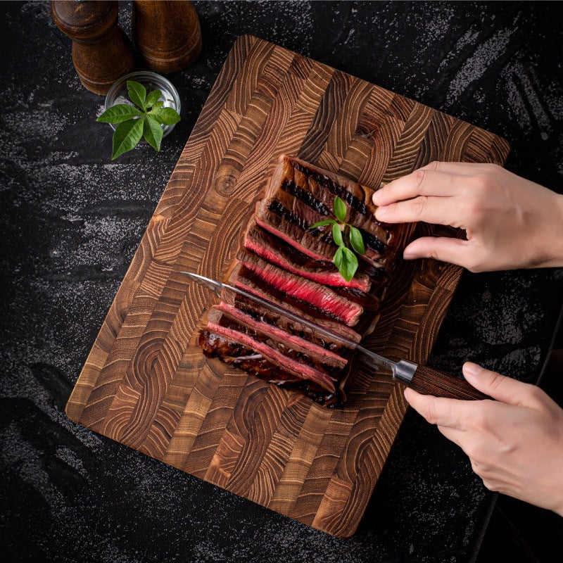 End-grain teak cutting board in use on a kitchen counter