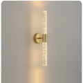 LED wall sconce in natural copper, slim vertical bubble-texture tube on a round plate, lit