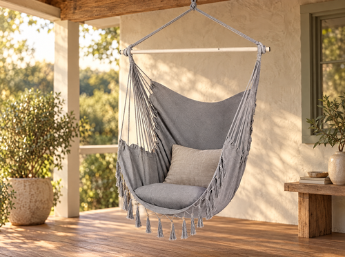 Canvas hanging chair with its rod spreader bar, suspended by rope on a covered porch