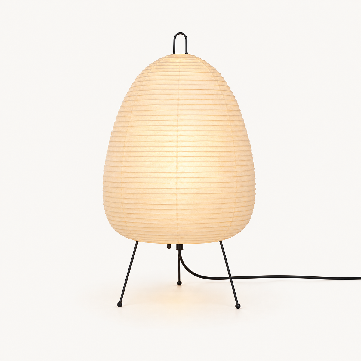 Rice paper lamp lit from within on a plain warm off-white background