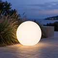 Glowing white globe light on a stone terrace at dusk